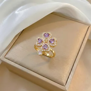 Dettaglio di un anello a quadrifoglio con zirconi viola a cuore su un portagioie