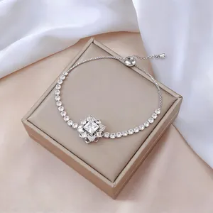 Detalle de una pulsera de flores plateada con circonitas y cierre deslizante ajustable