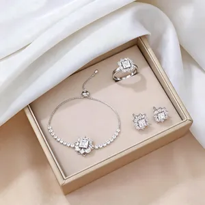 Detalle macro del conjunto de joyas de plata con circón cuadrado y diseño floral