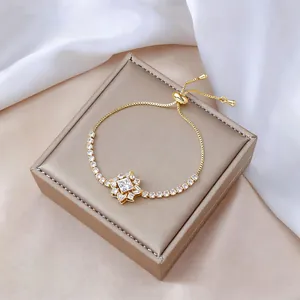 Primer plano de la pulsera ajustable de oro con estrella de circón en satén blanco