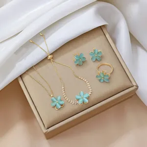 Elegante set di gioielli a fiore dorato con petali di opale blu e zirconi brillanti