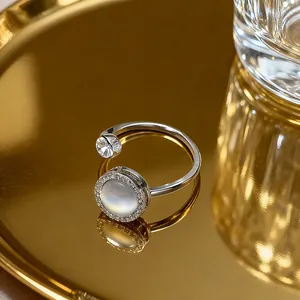 Detail of silver titanium ring with cat eye stone and diamonds on a gold tray