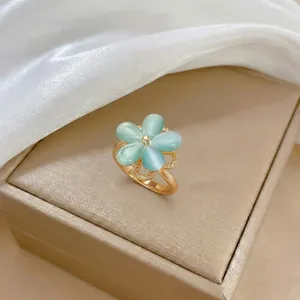 Dettaglio dell'anello a fiore dorato con petali in occhio di gatto blu e micro zirconi