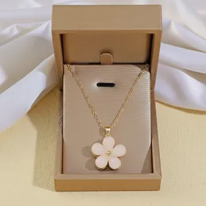 Dettaglio della collana a fiore con petali rosa in una confezione regalo dorata