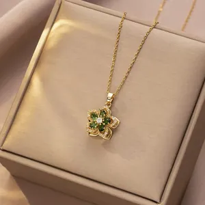 Detail of a rotating green zircon flower pendant on a dainty gold clavicle chain