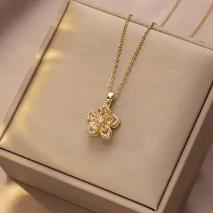 Macro detail of rotating gold flower pendant with pink stones on a jewelry box
