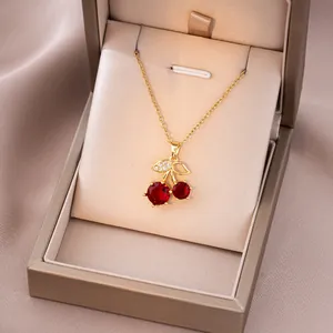 Détail d'un collier pendentif cerise dorée avec zircons rouges dans son écrin cadeau