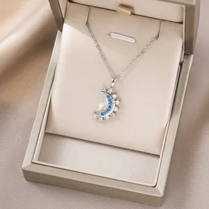 Detailsicht der silbernen Mondsichel-Halskette mit blau-weißen Steinen in Geschenkbox