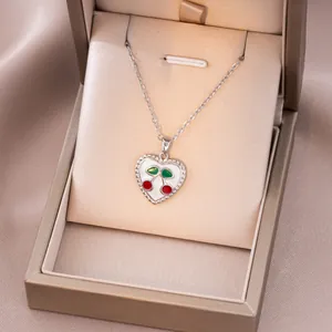 Détail du collier pendentif cerise en forme de cœur dans son coffret cadeau champagne luxe