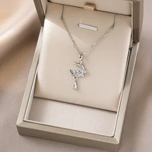 Detail der silbernen Mondsichel-Halskette mit weißen Steinen und Tropfenanhänger in Geschenkbox