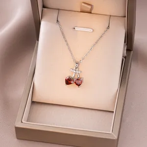 Détail d'un collier pendentif cerise rouge en forme de cœur dans son écrin de luxe
