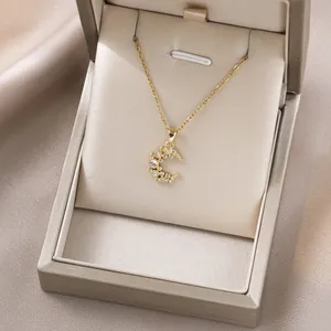 Goldene Mondsichel-Halskette mit funkelnden Kristallen in einer Geschenkbox für Schmuck