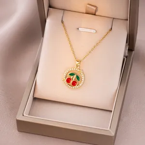 Détail du collier pendentif cerise avec cristaux dans un écrin cadeau en velours