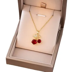 Collier cerise élégant avec cristaux rouges et chaîne dorée dans un écrin à bijoux