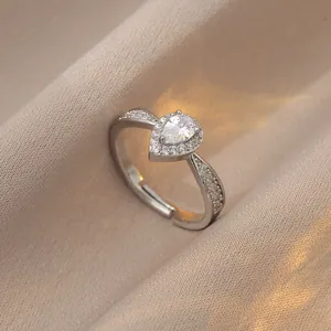 Elegant silver pear-shaped moissanite zircon ring with adjustable band on silk fabric