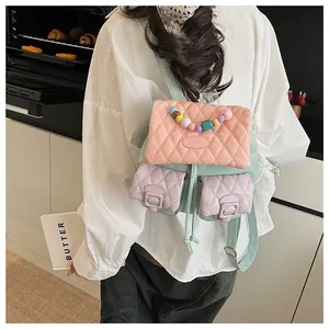 Detail of macaron quilted mini backpack with multi-color pearl handle and brand logo