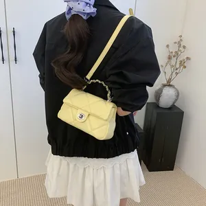 Petit sac bandoulière matelassé jaune avec fermoir rotatif argenté et poignée de chaîne