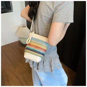 Detail einer bunt gestreiften gewebten Beuteltasche mit weißem Lederriemen am Model