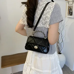 Sac à bandoulière matelassé noir chic avec sangle tissée et fermoir rotatif en métal