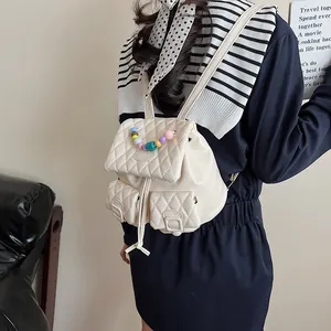 Quilted off-white mini backpack with colorful pearl handle and rhombus pattern texture