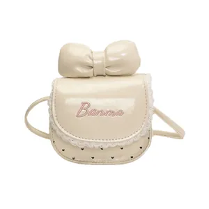 Mini cream leather crossbody bag with oversized bow and lace trim for kids