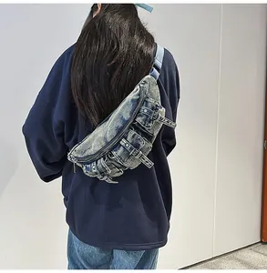 Détail d'un sac bandoulière en jean avec plusieurs poches et sangle ajustable sur modèle