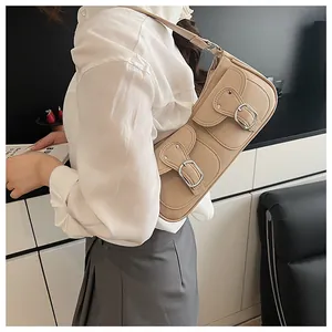 Detalle del bolso beige con dos bolsillos frontales y hebillas plateadas en cuero PU mate
