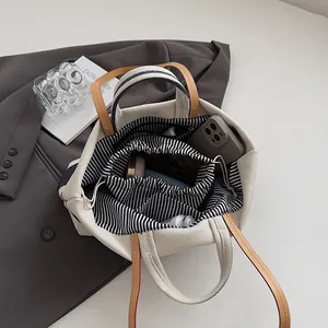 Large capacity off-white canvas tote bag with brown leather handles and striped lining