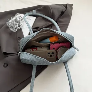 Light blue denim Boston bag showing large interior capacity with smartphone and wallet
