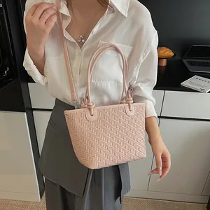Pink woven tote bag with adjustable strap and textured leather finish for women