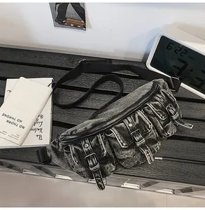 Détail du sac bandoulière en denim délavé avec trois poches cargo utilitaires
