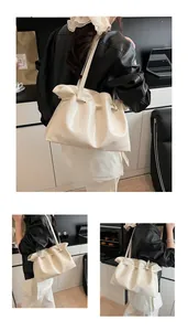 Detail view of large cream tote bag with drawstring texture and glossy pleated finish