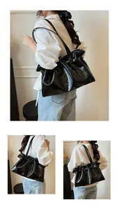 Detail showing the glossy oil wax leather texture and pleated design of the black tote bag