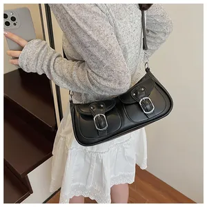 Primer plano detallado de un bolso de cuero negro con hebillas plateadas y bolsillos retro
