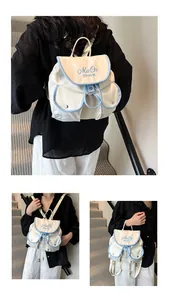 Detail of minimalist nylon backpack with blue trim and shark embroidery on beige fabric