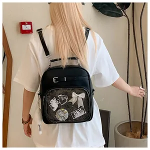 Detail of a black ita bag with transparent window featuring anime badges and white bow