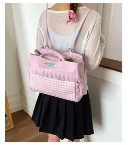 Détail du sac à dos en toile rose avec motif à carreaux et finitions à volants