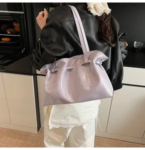 Light purple oversized tote bag in glossy wrinkled texture shown on model in home setting