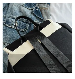 Close-up of the nylon backpack showing durable black webbing handle and stitching details