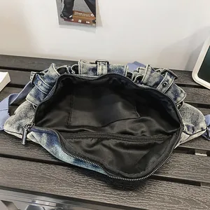 Intérieur spacieux du sac bandoulière en jean délavé avec doublure noire et fermeture éclair