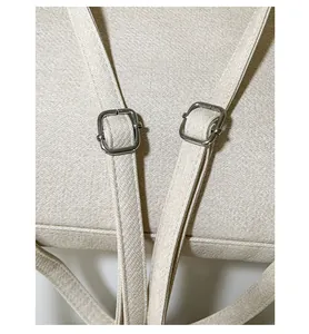 Détail du sac cabas en toile montrant le tissu texturé et la boucle en métal argenté