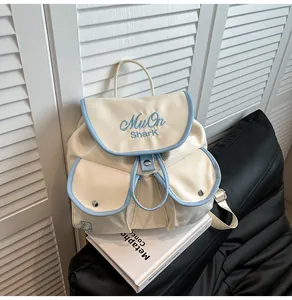 Close-up of nylon mini backpack with blue embroidery and cream color contrast detail