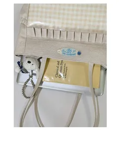 Vue de dessus d'un sac cabas en toile beige avec intérieur spacieux et doublure à carreaux