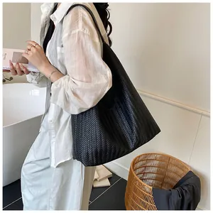 Detail of black woven leather tote bag texture with V-shaped pattern and large capacity