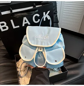 Detail of light blue nylon mini backpack with MuOn Shark embroidery and white trim