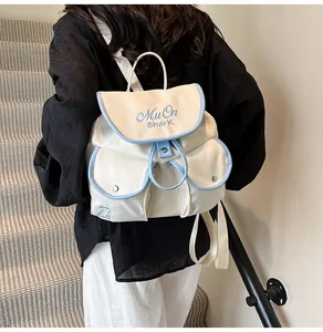 Detail of off-white nylon backpack with light blue trim and MuOn Shark embroidery detail