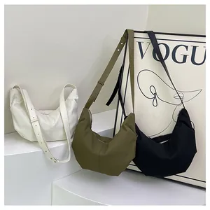 Dettaglio di borse hobo a pieghe in beige, verde e nero con tracolla regolabile