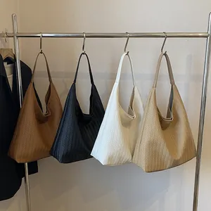 Minimalist woven texture tote bags in brown, black, white, and khaki shown on a rack