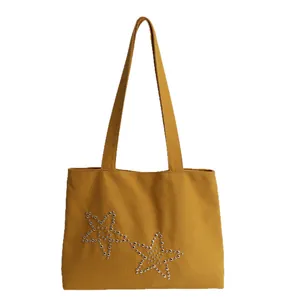 Minimalist mustard yellow canvas tote bag with trendy silver star rivet decorations