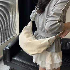 Borsa tote a mezzaluna in velluto a coste beige con tracolla regolabile sul modello